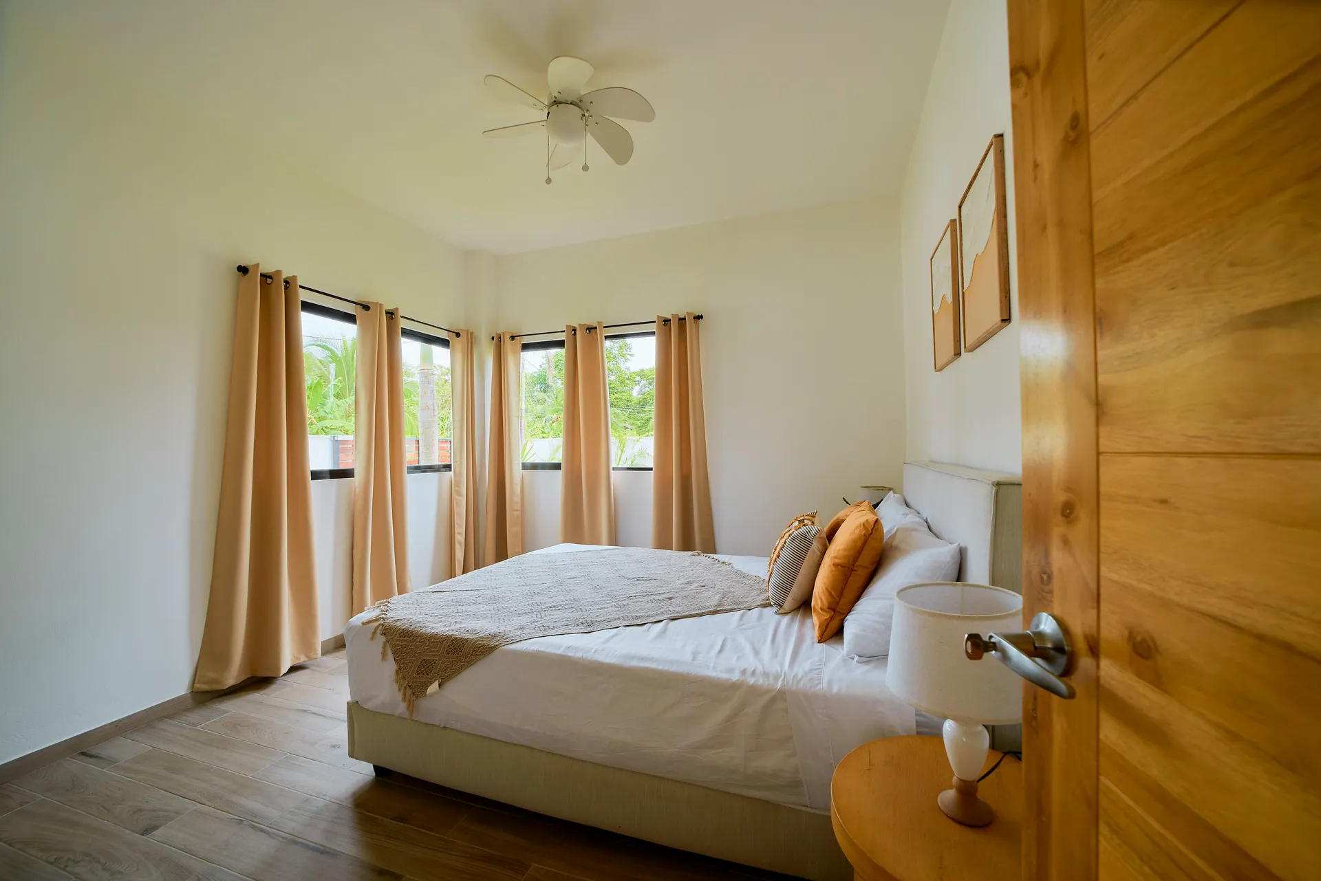 Habitación con cama queen de Casa Gray con ventanas esquineras y cortinas