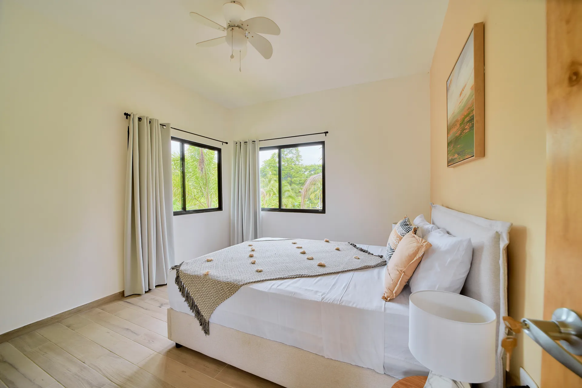 Habitación con cama queen de Casa Gray con ventana esquinera y luz del jardín