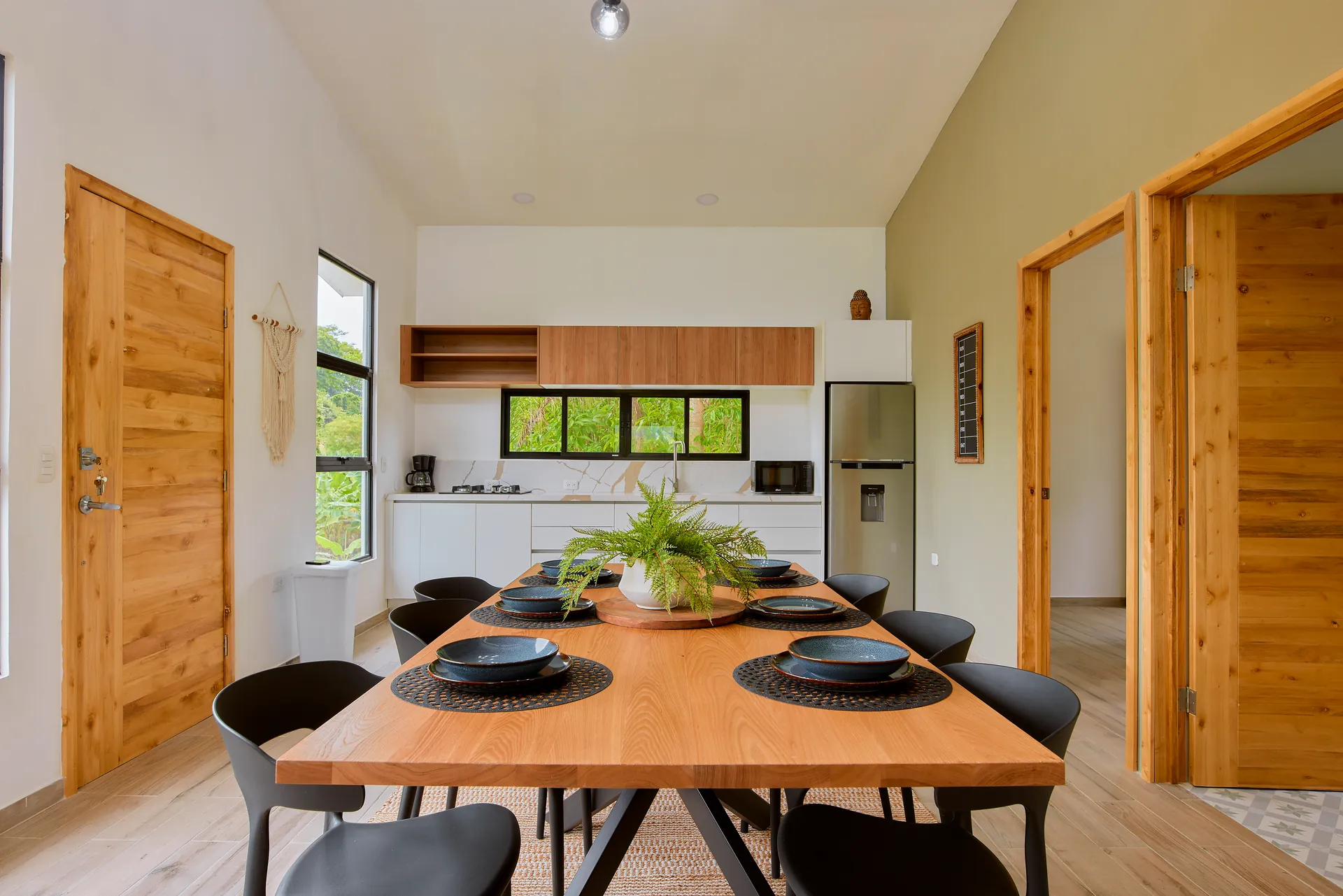 Mesa de comedor de Casa Gray con la segunda cocina al fondo