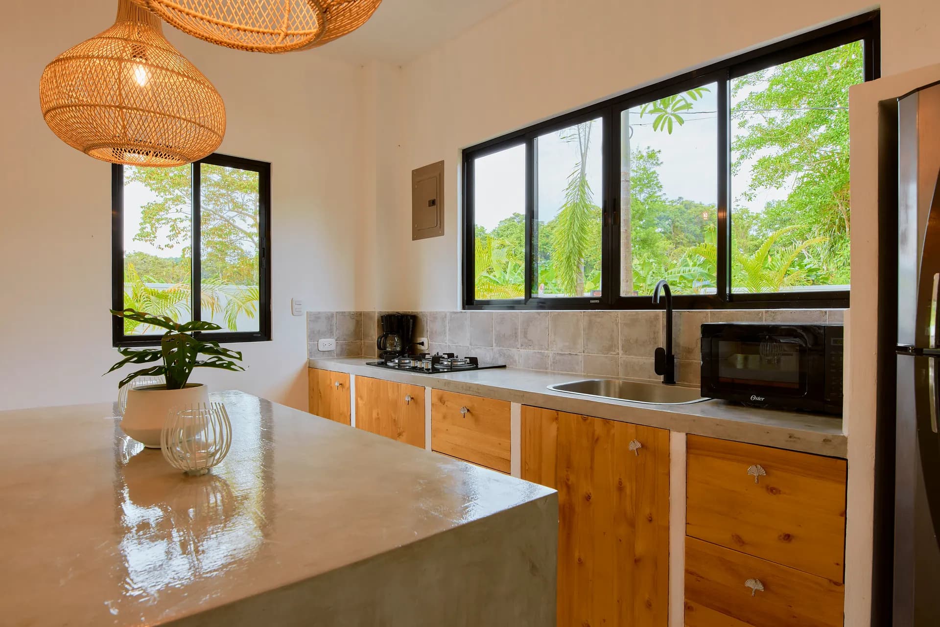 Isla de cocina de Casa Gray con lámparas colgantes de ratán