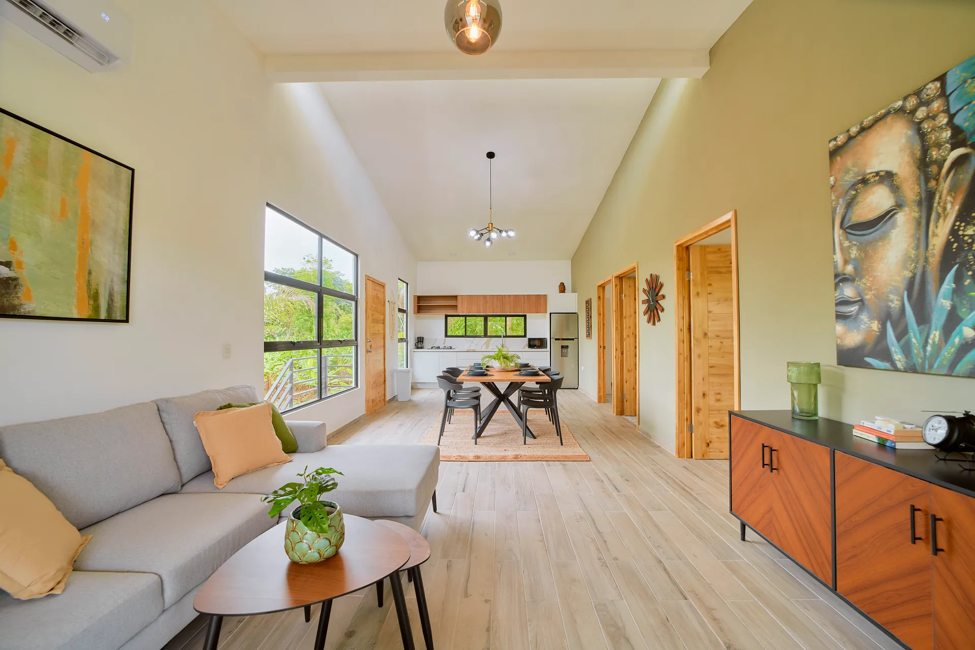 Sala de estar abierta de Casa Gray con sofá y comedor