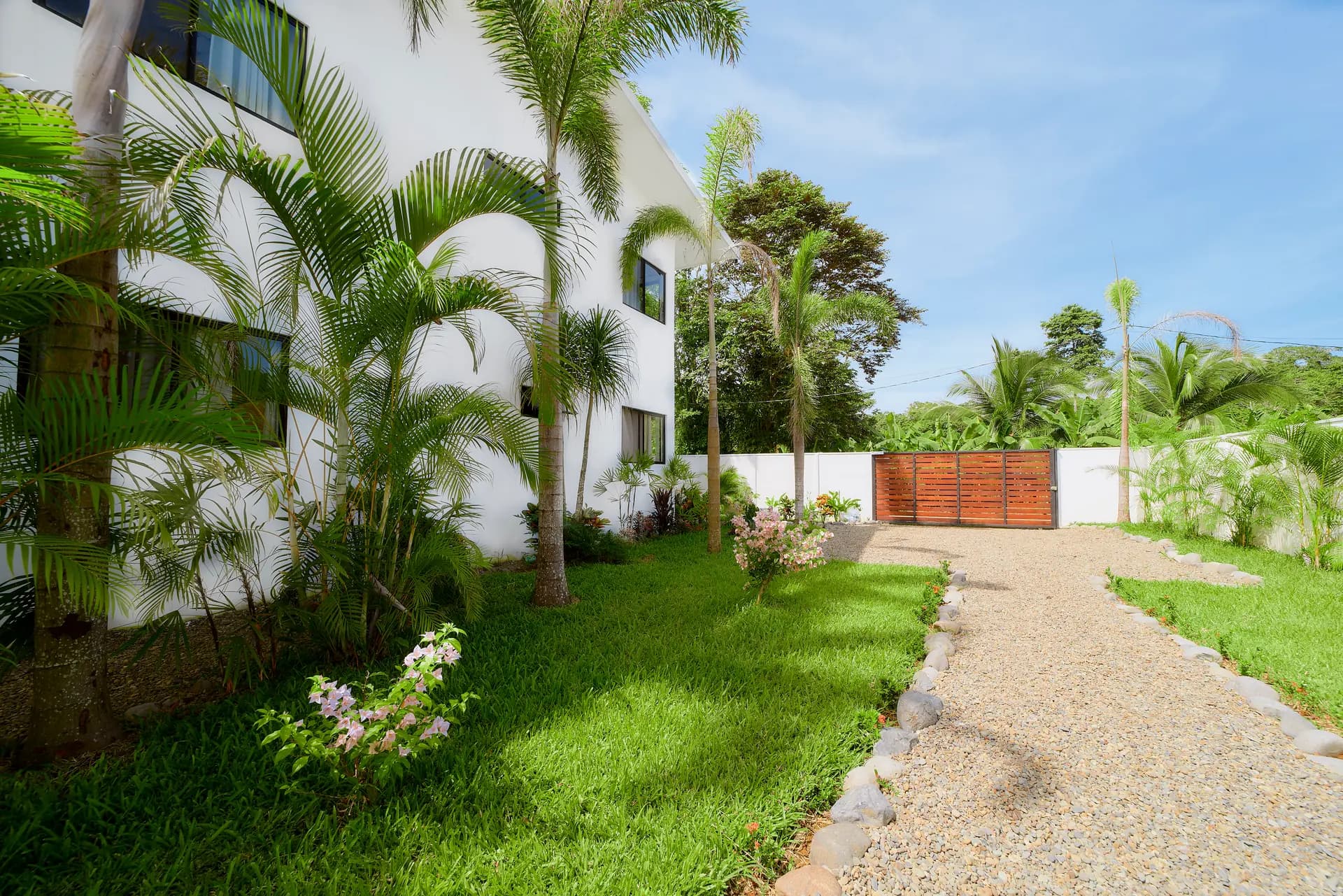 Jardín cercado de Casa Gray con portón de entrada