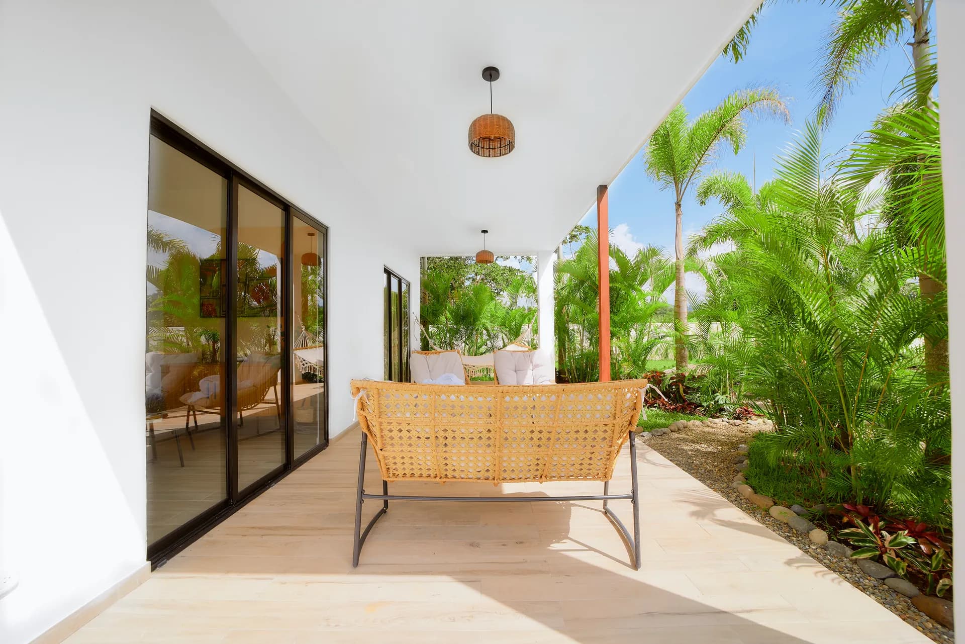 Terraza cubierta de Casa Gray con sofá de exterior