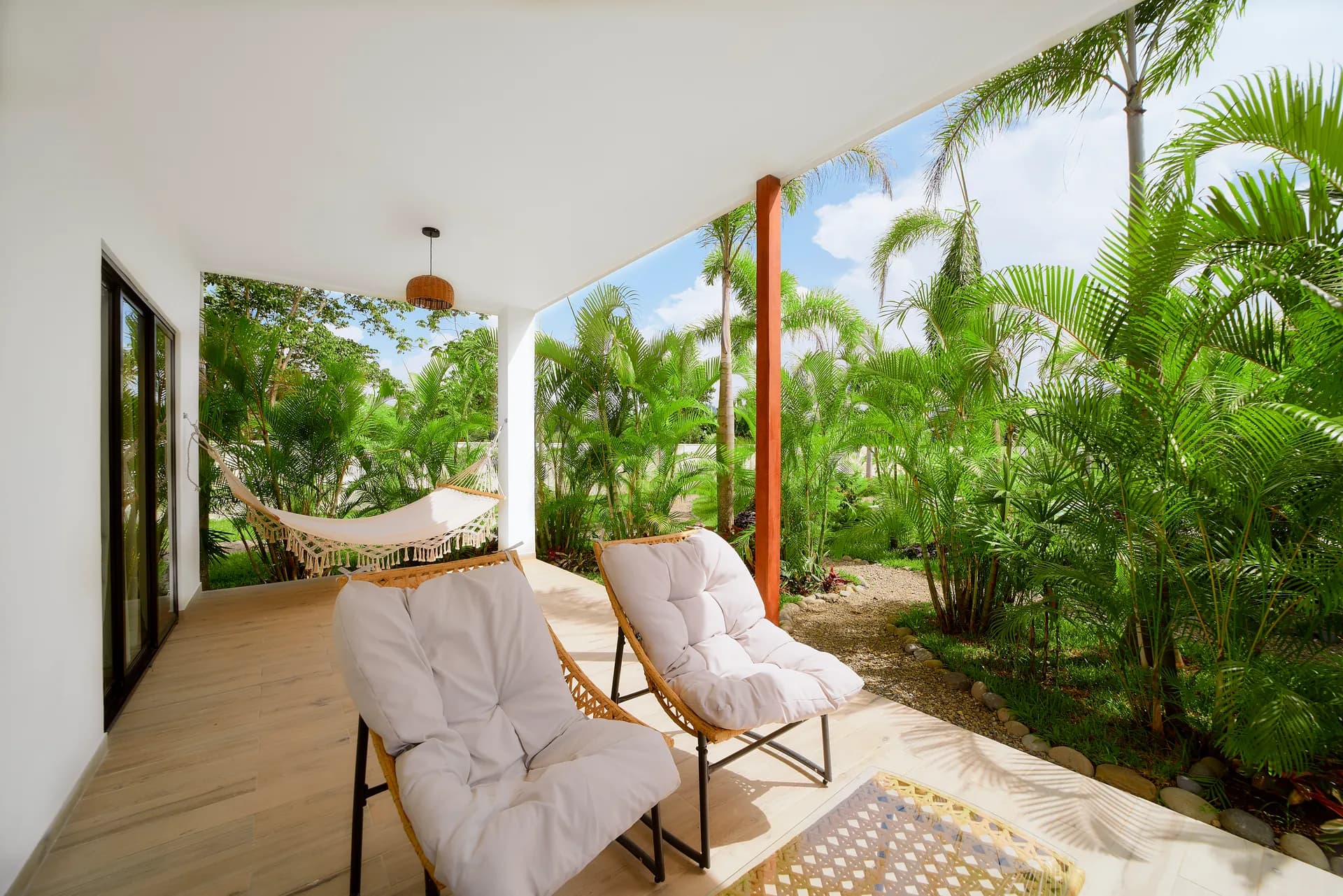 Terraza de Casa Gray con sillones y hamaca